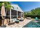 Outdoor living area featuring a screened lanai with comfortable seating and lush landscaping at 115 S Beverly Ave, Tampa, FL 33609
