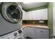 Well-organized laundry room features updated appliances and plenty of cabinet space at 115 S Beverly Ave, Tampa, FL 33609