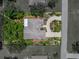 Aerial view featuring the home's well-maintained landscaping, mature trees, roof, and proximity to street at 11530 Arlhuna Way, Dade City, FL 33525