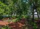 Secluded backyard with mature trees and vibrant flowers and plants at 11530 Arlhuna Way, Dade City, FL 33525