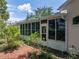 Exterior shot of a sunroom addition to the house, overlooking trees and the backyard at 11530 Arlhuna Way, Dade City, FL 33525