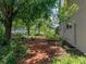Secluded backyard featuring mature trees and vibrant garden at 11530 Arlhuna Way, Dade City, FL 33525