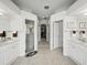 Hallway view to the bathroom featuring dual sinks, tiled flooring, and a walk-in shower at 11530 Arlhuna Way, Dade City, FL 33525