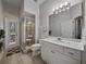 Bright bathroom with a walk-in shower, vanity, and access to the outdoor patio at 11530 Arlhuna Way, Dade City, FL 33525