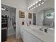Bathroom featuring dual sinks, a large mirror, and tiled flooring at 11530 Arlhuna Way, Dade City, FL 33525