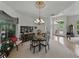 Bright dining room with a round table, chandelier, and views to the entryway and outside patio at 11530 Arlhuna Way, Dade City, FL 33525