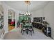 View of dining room featuring a circular black table with light chairs, a floral arrangement, and asian decor at 11530 Arlhuna Way, Dade City, FL 33525