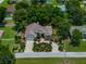 Exterior shot features the home's landscaping, driveway, attached garage, mature trees, and quiet street at 11530 Arlhuna Way, Dade City, FL 33525
