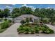 Beautifully landscaped single-story home featuring a curved driveway, manicured garden, and attached garage at 11530 Arlhuna Way, Dade City, FL 33525