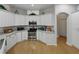 Well-lit kitchen featuring stainless appliances, white cabinetry, and a breakfast bar for casual dining at 11530 Arlhuna Way, Dade City, FL 33525