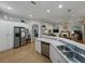 Open kitchen with stainless steel appliances, white cabinetry and a view into the living area at 11530 Arlhuna Way, Dade City, FL 33525