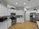 Modern kitchen with stainless steel appliances, ample white cabinetry, and views of the adjacent dining area at 11530 Arlhuna Way, Dade City, FL 33525