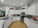 Spacious kitchen with white cabinets, stone countertops, and stainless-steel appliances, perfect for cooking at 11530 Arlhuna Way, Dade City, FL 33525
