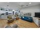 Open living room with a ceiling fan, hardwood floors, and an open-concept kitchen in the background at 11530 Arlhuna Way, Dade City, FL 33525