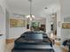 Spacious room featuring a grand piano with light wood flooring and views into other areas of the house at 11530 Arlhuna Way, Dade City, FL 33525