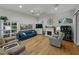 Bright living room featuring hardwood floors, a fireplace, and a blue leather couch, with natural light at 11530 Arlhuna Way, Dade City, FL 33525