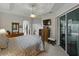 Well-lit main bedroom with a tray ceiling, fan, neutral carpet, an ensuite, and a slider at 11530 Arlhuna Way, Dade City, FL 33525