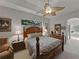 Comfortable main bedroom with tray ceiling, fan, neutral carpet, and a lovely ensuite bathroom at 11530 Arlhuna Way, Dade City, FL 33525