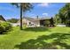 Sprawling backyard with lush lawn, mature trees, and a screened porch at 12219 Steppingstone Blvd, Tampa, FL 33635
