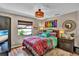 Bright bedroom with colorful bedding, a decorative light fixture, and a window at 12219 Steppingstone Blvd, Tampa, FL 33635