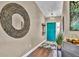 Foyer area with wood flooring, large mirror and teal front door at 12219 Steppingstone Blvd, Tampa, FL 33635