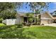 Landscaped front yard with lush green grass and mature trees on a sunny day at 12219 Steppingstone Blvd, Tampa, FL 33635