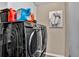 Laundry area features a modern washer and dryer with detergent and an artistic print at 12219 Steppingstone Blvd, Tampa, FL 33635
