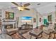 Cozy living room with stone fireplace, modern ceiling fan, and beach-themed television display at 12219 Steppingstone Blvd, Tampa, FL 33635
