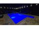 Inviting backyard pool at night, featuring custom lighting, patio, and lounge seating at 12219 Steppingstone Blvd, Tampa, FL 33635