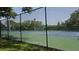 Well-maintained tennis court with a new net and surrounding fence, ready for a match at 12219 Steppingstone Blvd, Tampa, FL 33635