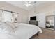 This primary bedroom has vaulted ceilings, neutral paint, barn door to bathroom, and a TV mounted over a dresser at 12229 Coldstream Ln, Tampa, FL 33626
