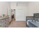 Neutral bedroom featuring a crib, dresser, and bi-fold closet at 12229 Coldstream Ln, Tampa, FL 33626