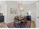 Dining area with seating for six, a patterned rug, and an eye-catching light fixture at 12229 Coldstream Ln, Tampa, FL 33626