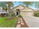 Inviting single-story home with a stone pathway, lush lawn, and a classic two-car garage at 12229 Coldstream Ln, Tampa, FL 33626