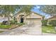 Charming single-story home featuring a well-kept lawn, mature trees, and a two-car garage at 12229 Coldstream Ln, Tampa, FL 33626