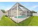 Exterior shot of a private screened pool in a well-maintained yard surrounded by a secure white fence at 12229 Coldstream Ln, Tampa, FL 33626