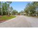 Picturesque street leading to a gated community, surrounded by tall trees and green lawns at 12229 Coldstream Ln, Tampa, FL 33626