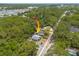 Overhead shot displays the house and a fenced in yard surrounded by large trees and foliage at 1235 Bass Blvd, Dunedin, FL 34698