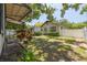 Fenced backyard features mature trees, paved walkways, and lush greenery creating a private outdoor space at 1235 Bass Blvd, Dunedin, FL 34698