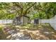 Backyard featuring mature trees, a fenced perimeter, storage shed and paved walkway at 1235 Bass Blvd, Dunedin, FL 34698