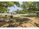 Residential backyard with partial shade from trees, a white fence, and the exterior of the home at 1235 Bass Blvd, Dunedin, FL 34698