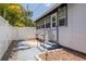 Home's backyard with steps leading up to screened in porch, secure fence, and green space at 1235 Bass Blvd, Dunedin, FL 34698