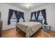 Bright bedroom featuring hardwood floors, three windows and a ceiling fan at 1235 Bass Blvd, Dunedin, FL 34698