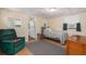 Cozy bedroom with a green chair, ceiling light, window with dark curtains, and view of kitchen at 1235 Bass Blvd, Dunedin, FL 34698