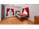 Sunlit bedroom with wood floors, red accents, and cozy decor at 1235 Bass Blvd, Dunedin, FL 34698