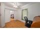 Bedroom with hardwood floors, ceiling fan, and a desk area; view into another bedroom at 1235 Bass Blvd, Dunedin, FL 34698