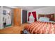 Bright bedroom featuring hardwood floors, a patterned blanket, and adjacent bathroom at 1235 Bass Blvd, Dunedin, FL 34698