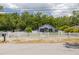 Charming home with a well-kept lawn, white picket fence, and mature trees providing shade at 1235 Bass Blvd, Dunedin, FL 34698