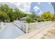 Charming fenced home featuring a well-maintained lawn, mature trees, and a spacious driveway at 1235 Bass Blvd, Dunedin, FL 34698