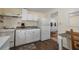 Functional kitchen space featuring white appliances, laminate counters, and view of bedroom at 1235 Bass Blvd, Dunedin, FL 34698